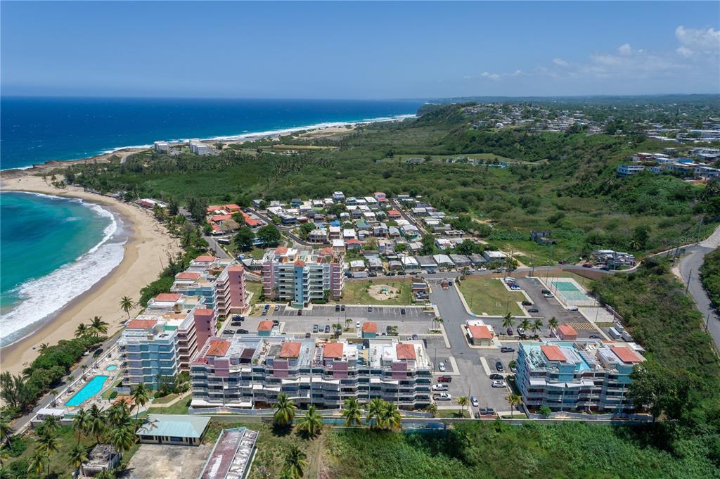 An aerial view shows a beachfront apartment complex with swimming pools and surrounding coastal vegetation — 1 ISABELA BEACH COURT UNIT 752, ISABELA, PR