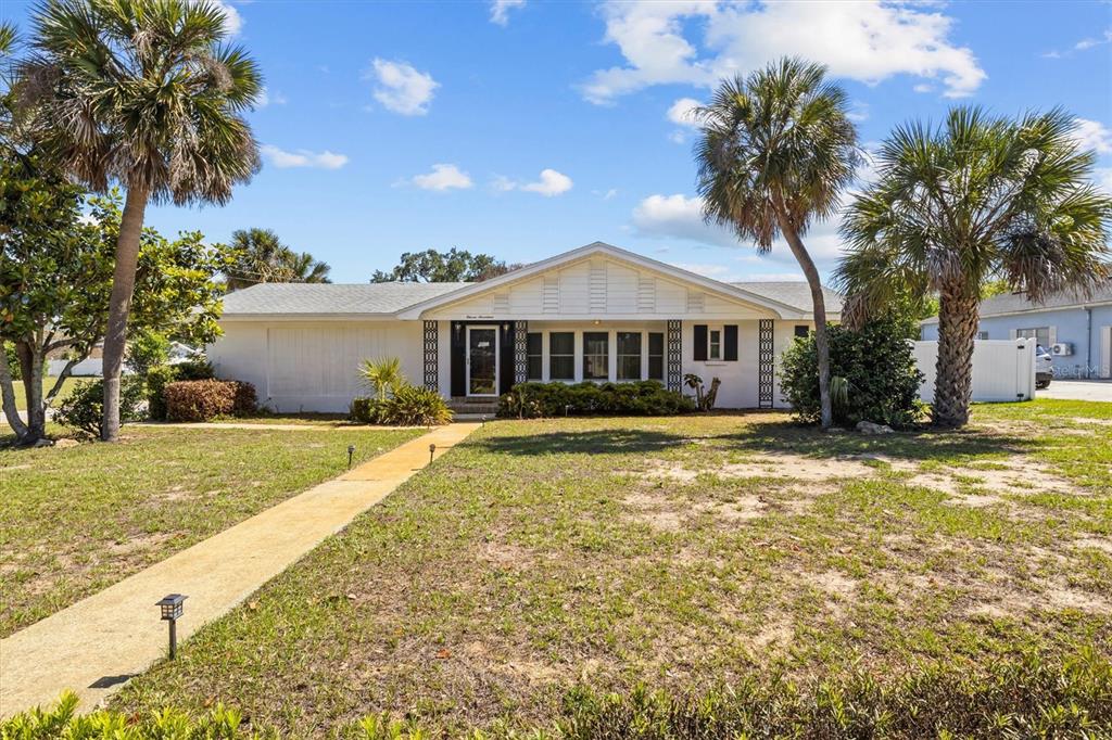 A single-story white house with a gabled roof and palm trees in the front yard — 1117 N LAKESHORE BOULEVARD, LAKE WALES, FL