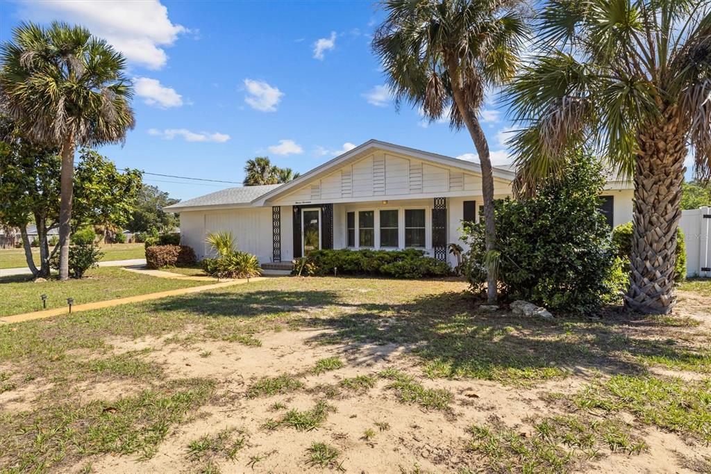 A single-story white house with a gabled roof sits on a grassy lot with palm trees — 1117 N LAKESHORE BOULEVARD, LAKE WALES, FL