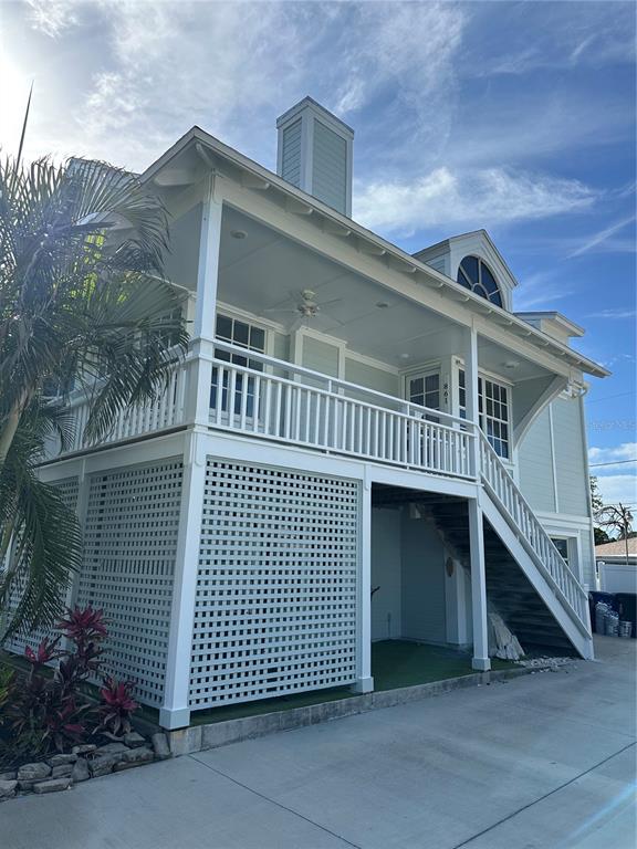 A two-story house with a raised porch, white lattice skirting, and an exterior staircase — 861 NECTAR ROAD, VENICE, FL