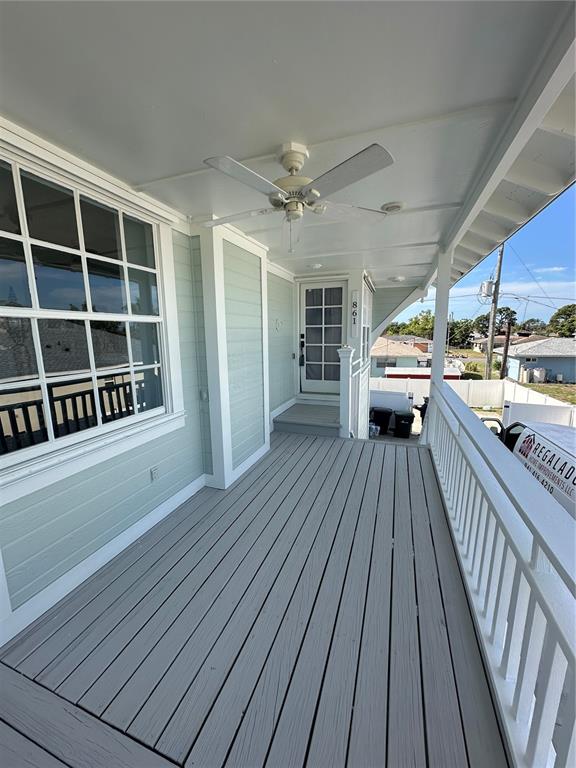 A covered porch with light green siding, a ceiling fan, and a white railing — 861 NECTAR ROAD, VENICE, FL