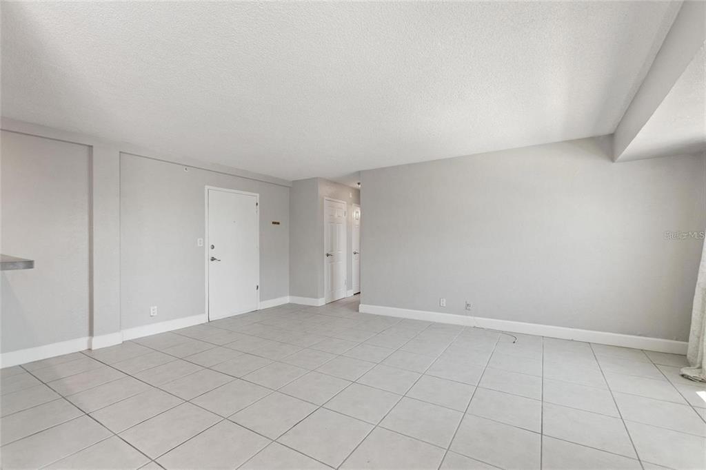 An empty room features light gray walls, white trim, and large square floor tiles — 3315 58TH AVENUE S UNIT 314, ST PETERSBURG, FL