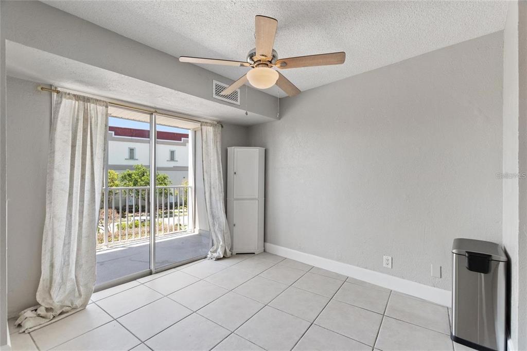 A room with light tile flooring, a ceiling fan, and a sliding glass door to a balcony — 3315 58TH AVENUE S UNIT 314, ST PETERSBURG, FL