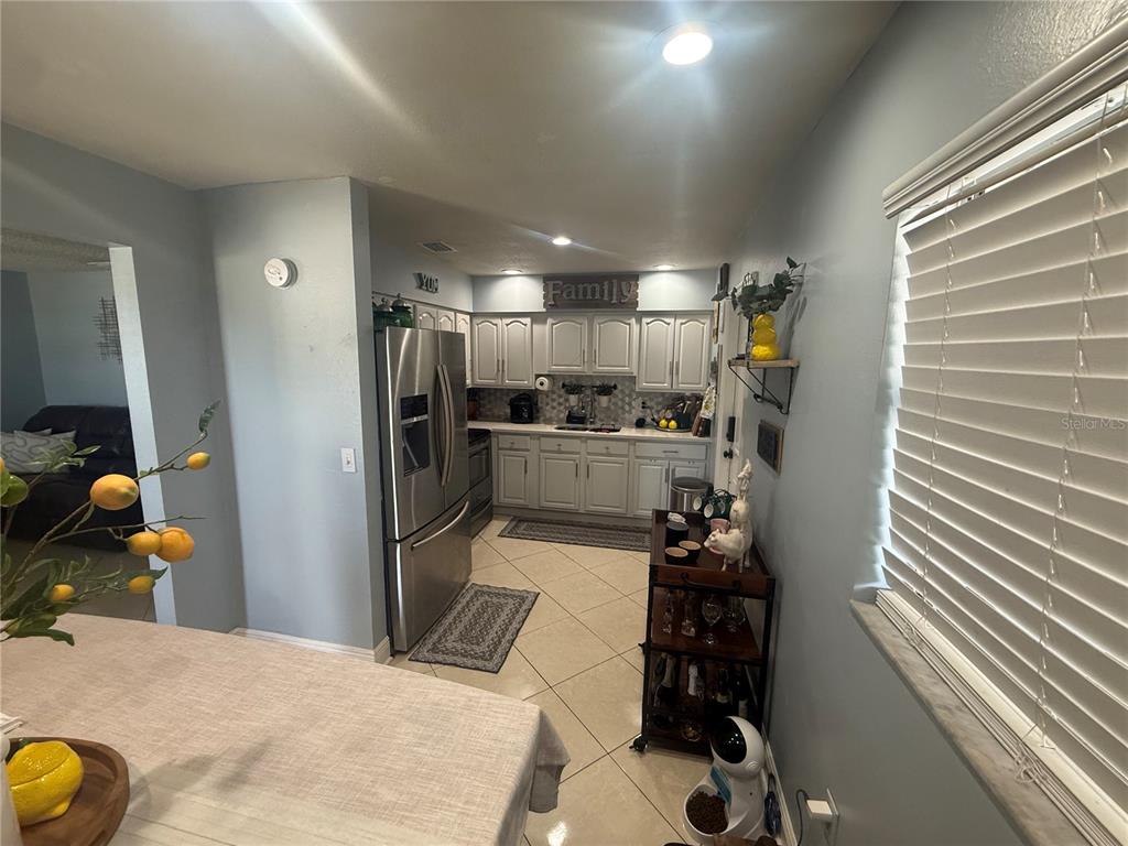 A kitchen features white cabinets, stainless steel appliances, and tile flooring — 4808 SIERRA MADRE DRIVE, TAMPA, FL