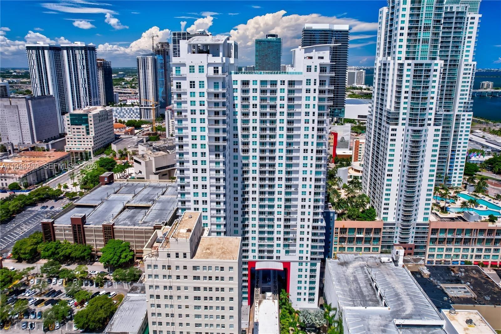 An aerial view of a tall white residential skyscraper in a dense urban city — 133 NE 2nd Ave # 2013, Miami FL 33132, MIAMI, FL
