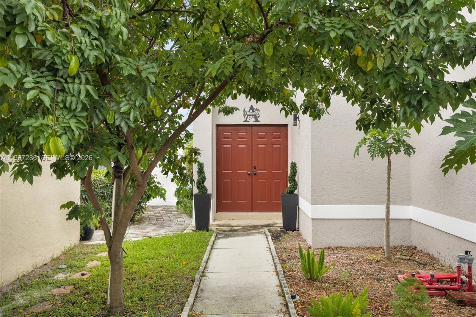 A concrete walkway leads to a set of double red doors at a house entrance — 8317 Bermuda Sound Way, Boynton Beach FL 33436, BOYNTON BEACH, FL