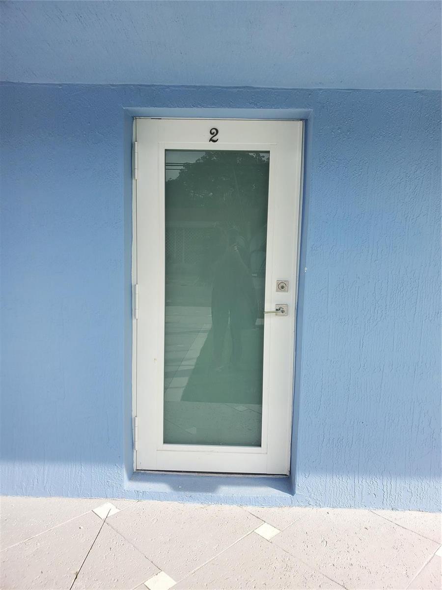 A white door with a glass panel and the number two sits in a blue wall — 70 NW 13th Avenue # 2, Dania Beach FL 33004, DANIA BEACH, FL