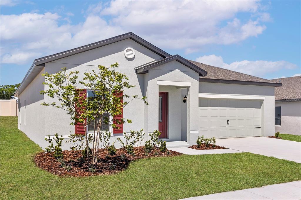 A single-story house with light gray stucco, a red front door, and a two-car garage — 1802 WHITE ELEPHANT LOOP, WINTER HAVEN, FL