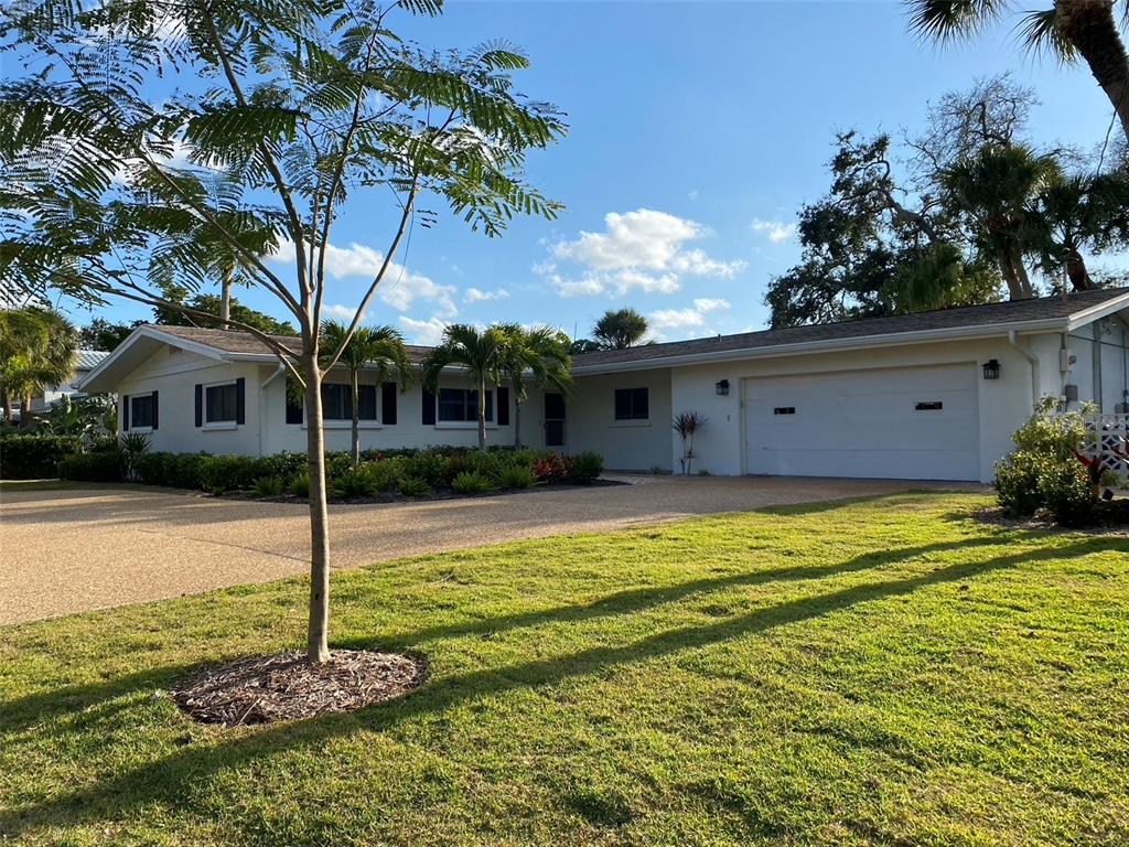 A single-story house with a white exterior, a two-car garage, and a large front lawn — 814 PARADISE WAY, SARASOTA, FL