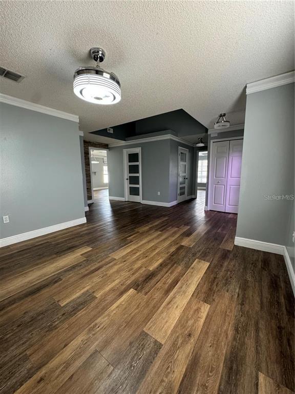 A room with light blue walls, wood-look flooring, and a ceiling fan with a light — 604 TAMARIN LANE, KISSIMMEE, FL