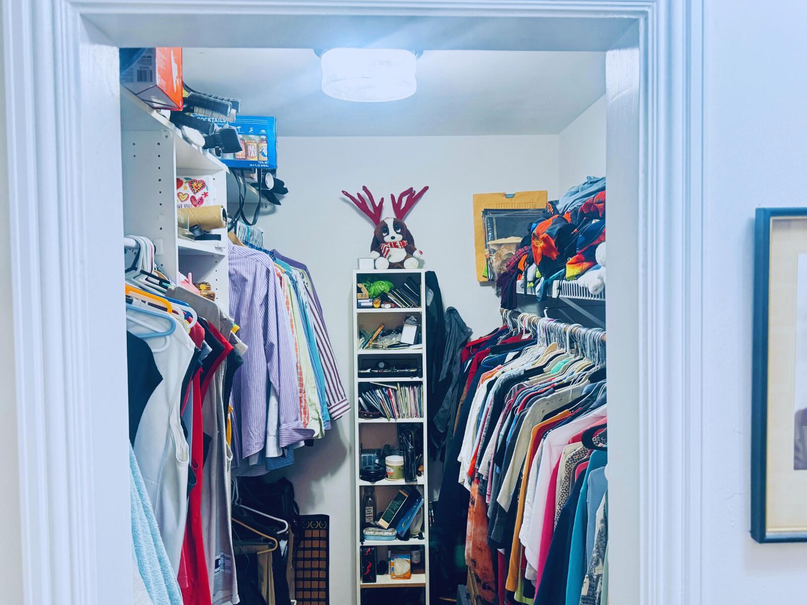 A walk-in closet features hanging clothes on both sides and a central shelving unit — 3209 Norfolk Street, Pompano Beach FL 33062, POMPANO BEACH, FL