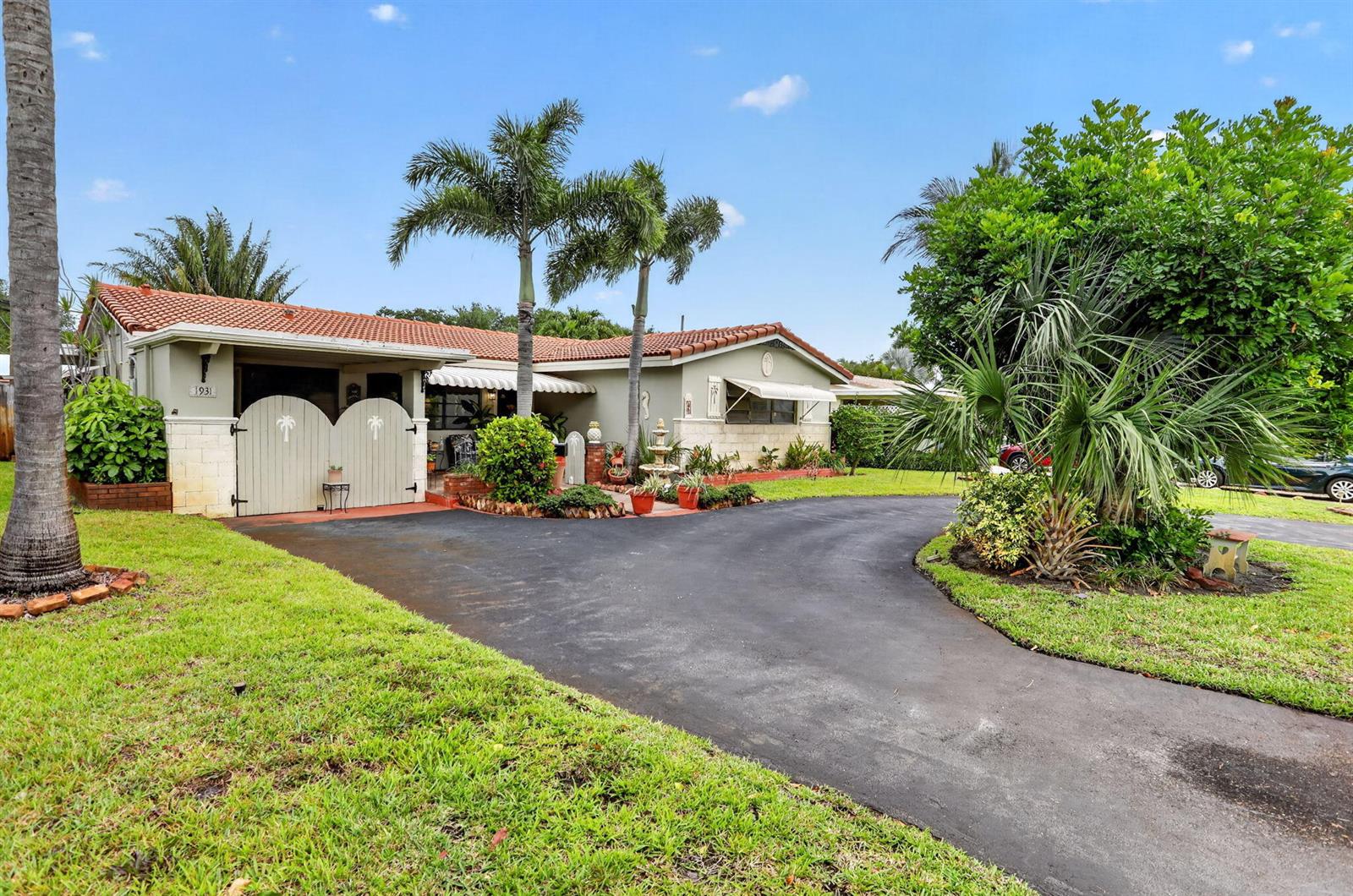 A single-story house with a tile roof, palm trees, and a paved driveway — 1931 NE 27th Street, Lighthouse Point FL 33064, LIGHTHOUSE POINT, FL