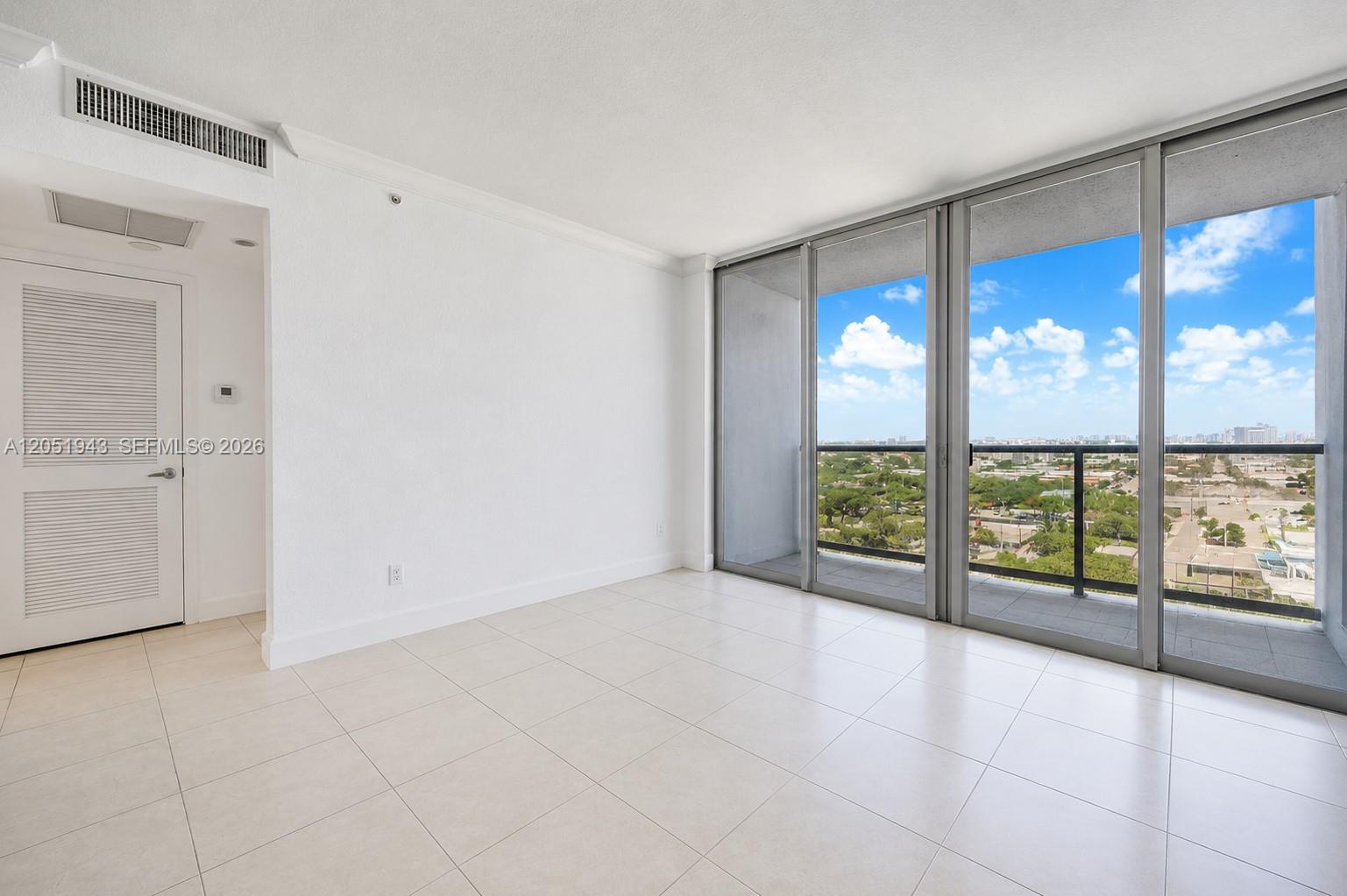 An empty room with white tile floors, white walls, and large sliding glass balcony doors — 401 69th St # 1411, Miami Beach FL 33141, MIAMI BEACH, FL