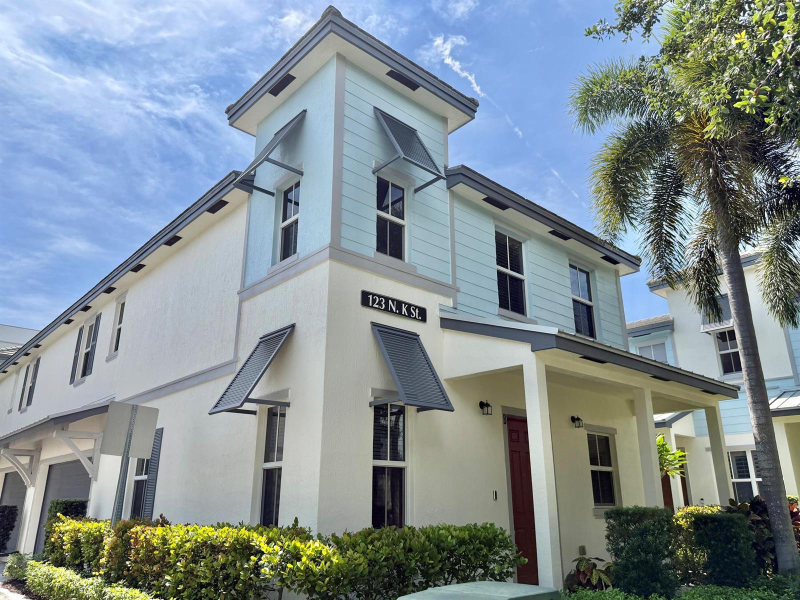 A two-story house with light blue and white siding features a covered porch and shutters — 123 N K Street # B, FL 33460, FL