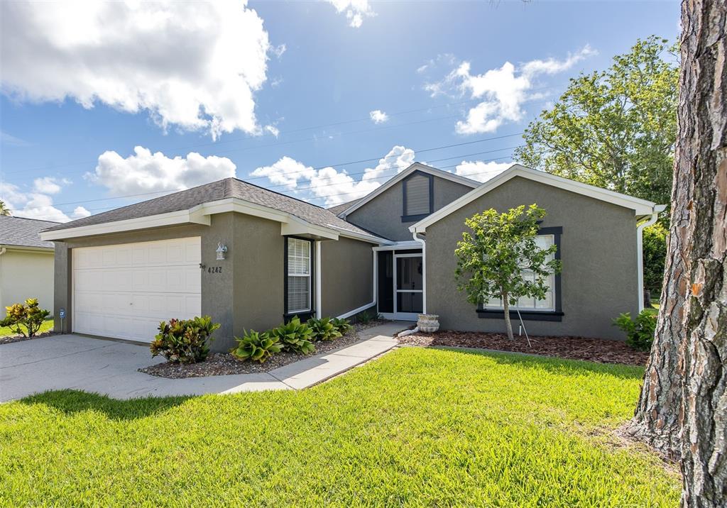 A single-story house with a gray exterior, a two-car garage, and a front lawn — 4242 NORTHAMPTON DRIVE, NEW PORT RICHEY, FL