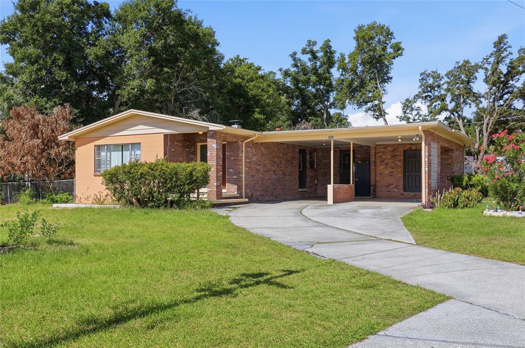 A single-story brick house with a carport and a concrete driveway on a grassy lot — 620 W CUMMINGS STREET, LAKE ALFRED, FL