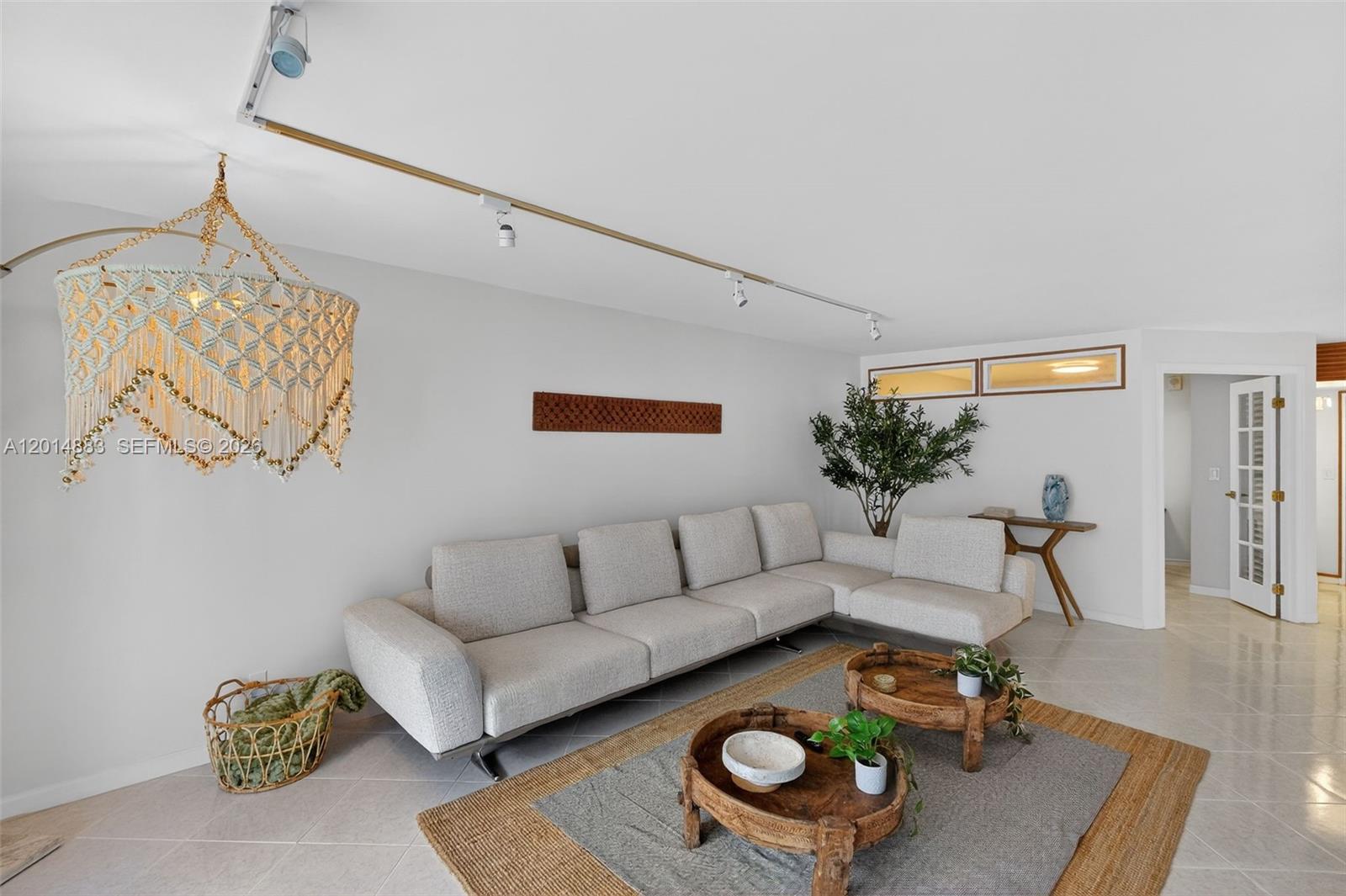 A living room features a sectional sofa, two wooden coffee tables, and a macrame chandelier — 2401 Collins Ave # 1406, Miami Beach FL 33140, MIAMI BEACH, FL