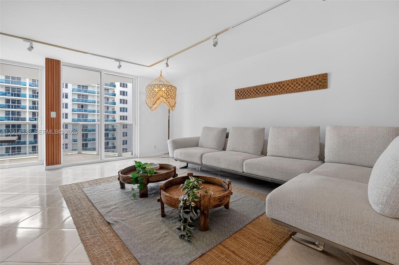 A living room features a light gray sectional sofa, two wooden coffee tables, and balcony views — 2401 Collins Ave # 1406, Miami Beach FL 33140, MIAMI BEACH, FL