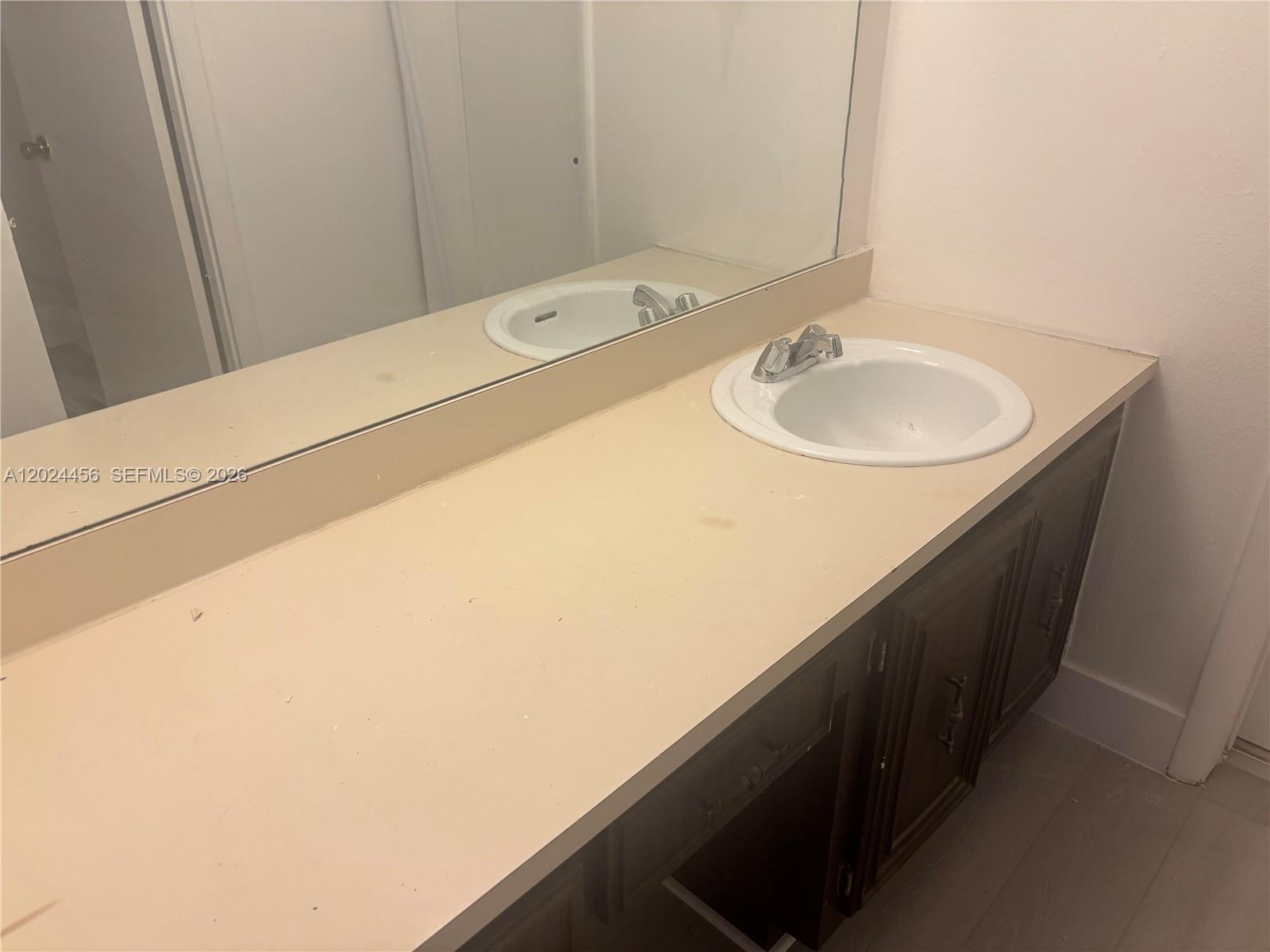 A bathroom features a white bathtub, a toilet, and a vanity with a sink — 484 NW 165th St Rd # 111, Miami FL 33169, MIAMI, FL
