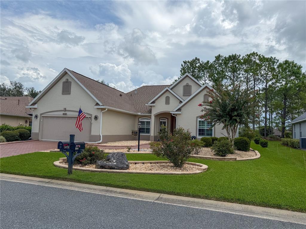 A single-story suburban house with a beige stucco exterior, a two-car garage, and landscaped yard — 8565 SW 82ND TERRACE, OCALA, FL