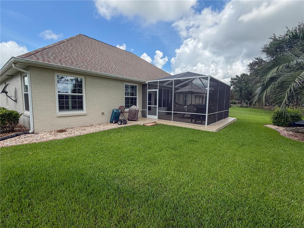 The exterior view shows a house with a screened-in patio and a grassy backyard — 8565 SW 82ND TERRACE, OCALA, FL