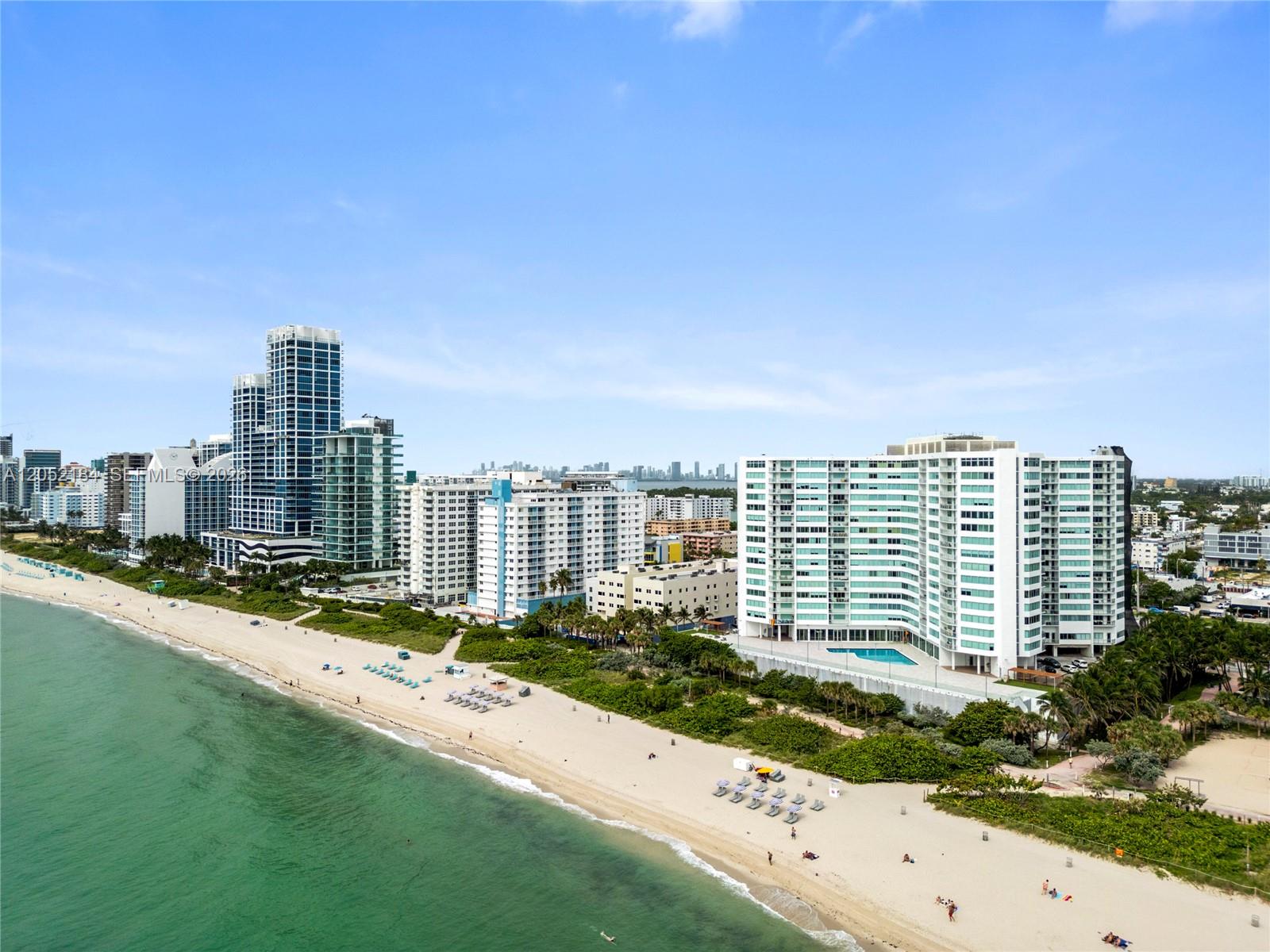 An aerial view shows high-rise residential buildings along a sandy beach and ocean — 7135 Collins Ave # 1535, Miami Beach FL 33141, MIAMI BEACH, FL