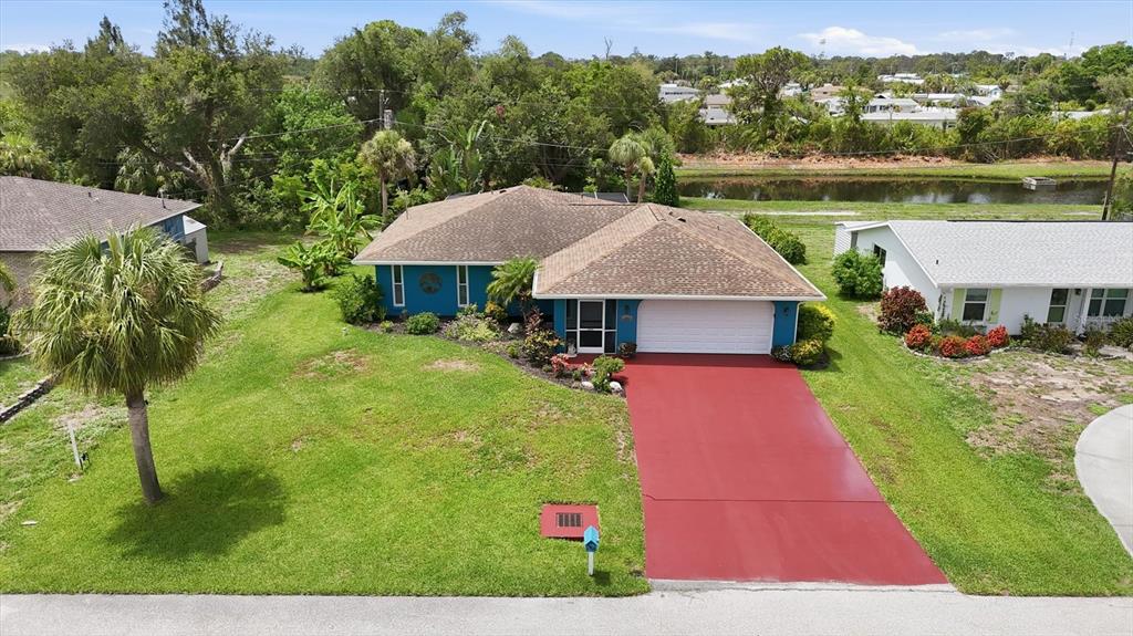 An aerial view shows a blue house with a red driveway and a brown roof — 383 E WENTWORTH CIRCLE, ENGLEWOOD, FL