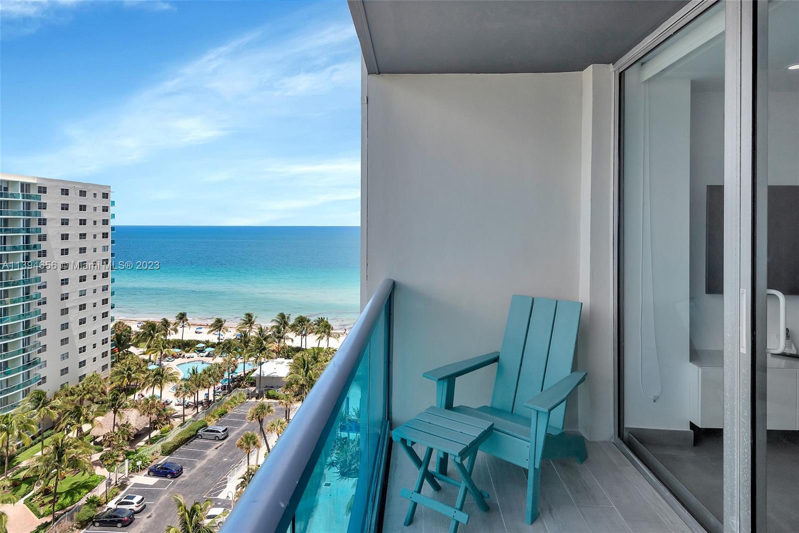 A balcony features a light blue Adirondack chair and side table overlooking the ocean — 4001 S Ocean Dr # 14H, Hollywood FL 33019, HOLLYWOOD, FL