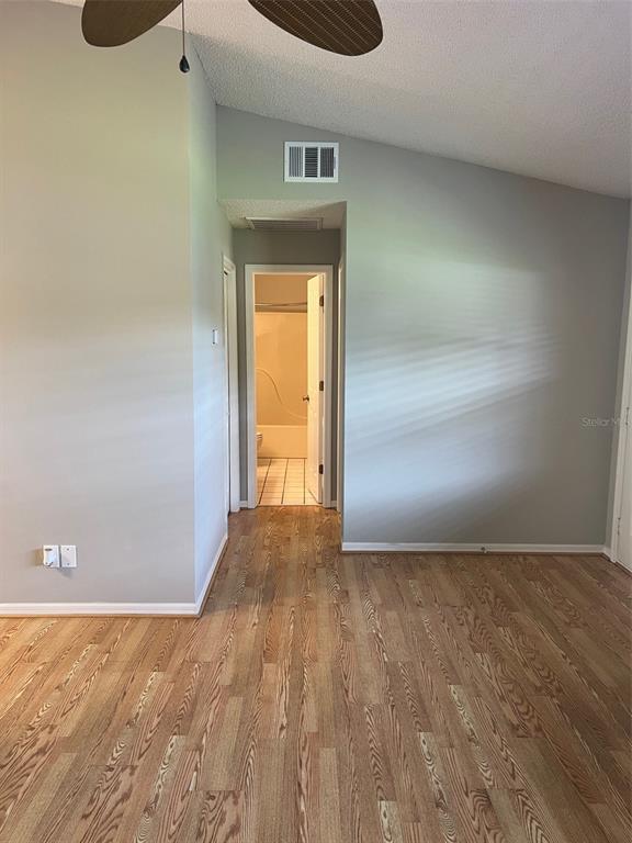 A room with wood-look flooring leads to a hallway and a bathroom — 12449 ORANGEWOOD CIRCLE UNIT 17, TAVARES, FL
