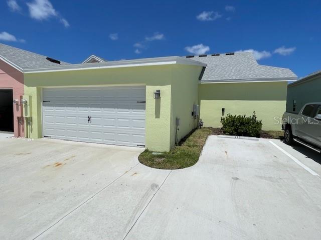 A light yellow house features a white garage door and a concrete driveway — 261 GYPSY PALACE LANE, DAYTONA BEACH, FL