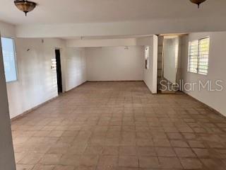 An empty room with tiled flooring, white walls, and two ceiling light fixtures — PR 1 Km 18.7 Int. SANCHEZ CAIMITO BAJO, SAN JUAN, PR