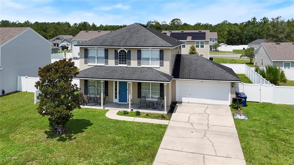 An aerial view of a two-story suburban house with a garage and a front lawn — 586 INDEPENDENCE DRIVE, MACCLENNY, FL
