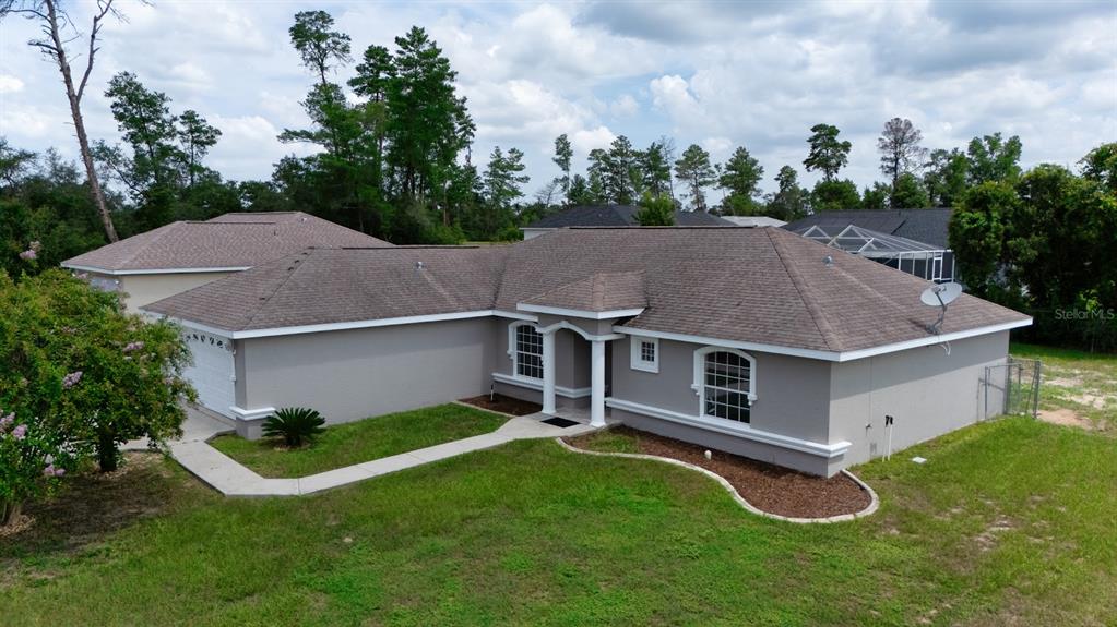 An aerial view of a single-story gray house with a brown shingled roof — 14771 SW 27TH COURT ROAD, OCALA, FL