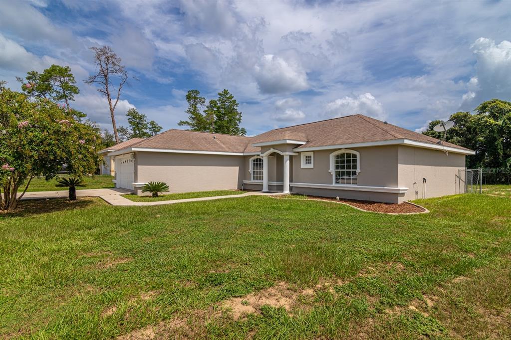 A single-story beige house with a brown roof and a front porch with columns — 14771 SW 27TH COURT ROAD, OCALA, FL