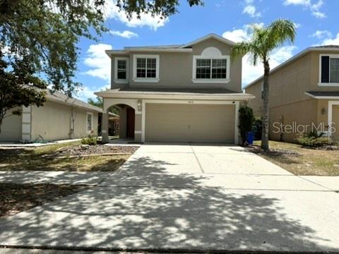 A two-story suburban house with a beige exterior, a two-car garage, and a palm tree — 1631 SHERBOURNE STREET, WINTER GARDEN, FL