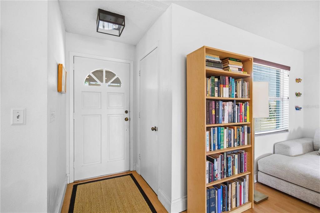 An entryway features a white front door, a wooden bookshelf, and a light-colored sofa — 5031 PRESTON WAY, SARASOTA, FL