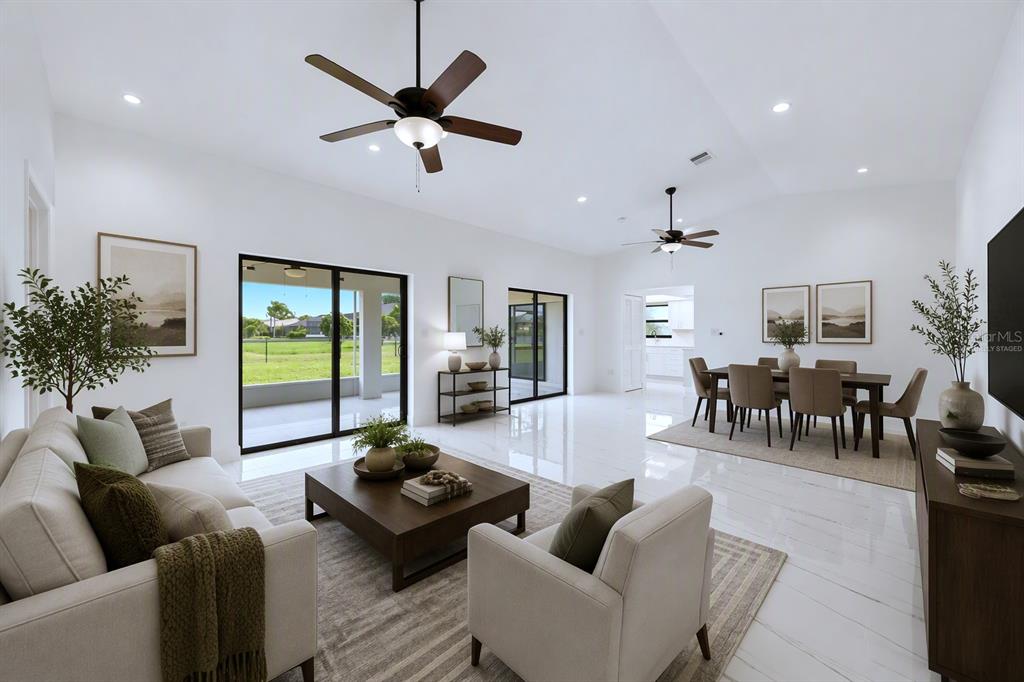 A bright, open-concept living and dining area features white tile floors and vaulted ceilings — 2705 MAURITANIA ROAD, PUNTA GORDA, FL