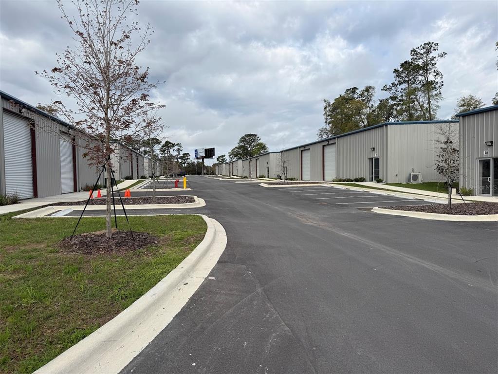 An exterior view of a commercial warehouse complex with paved parking and metal buildings — 5741 S PINE AVENUE, OCALA, FL