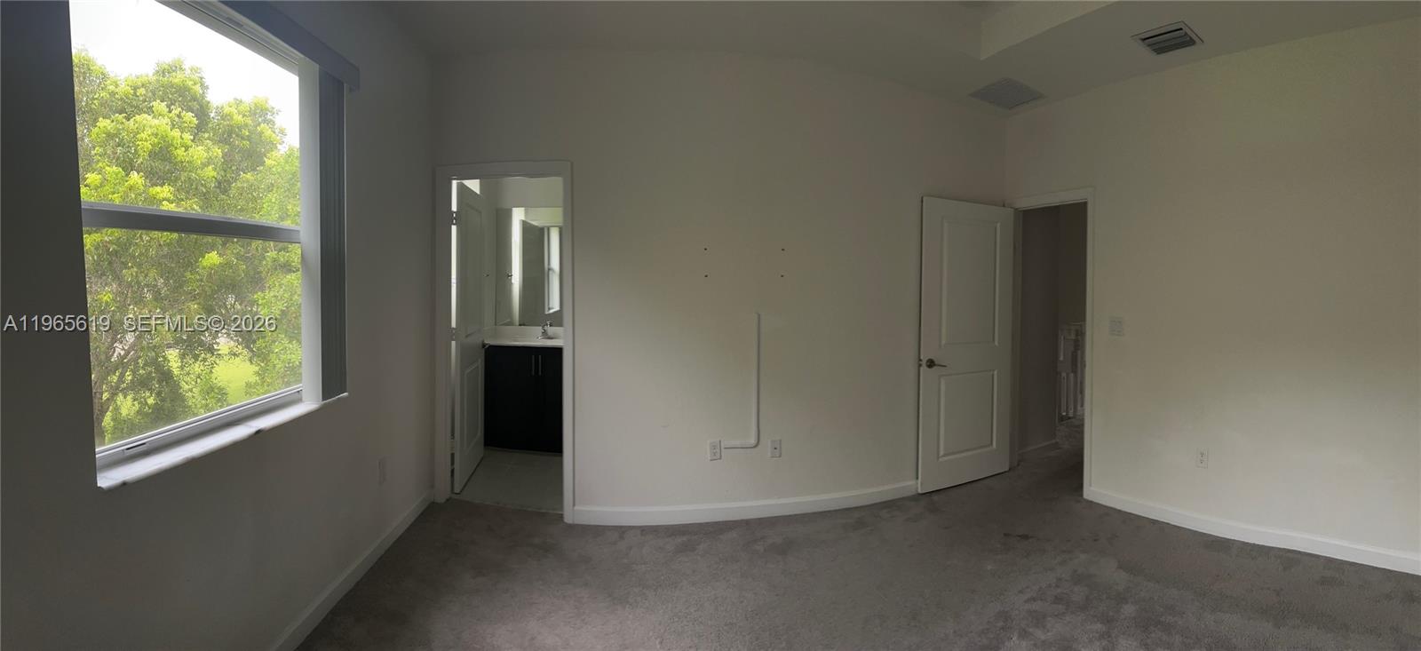 A bedroom with gray carpet, white walls, a window, and two doorways — 2672 SE 19th St, Homestead FL 33035, HOMESTEAD, FL