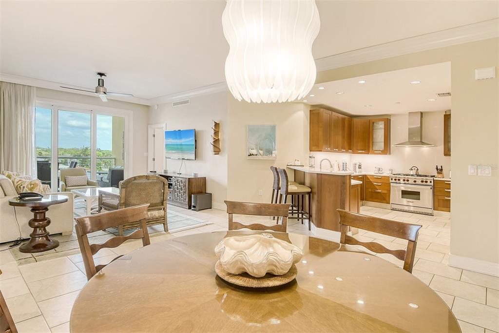 An open-concept living and dining area features a kitchen with wood cabinets and tile flooring — 915 SEASIDE DRIVE UNIT 312, Weeks 16-17, SARASOTA, FL
