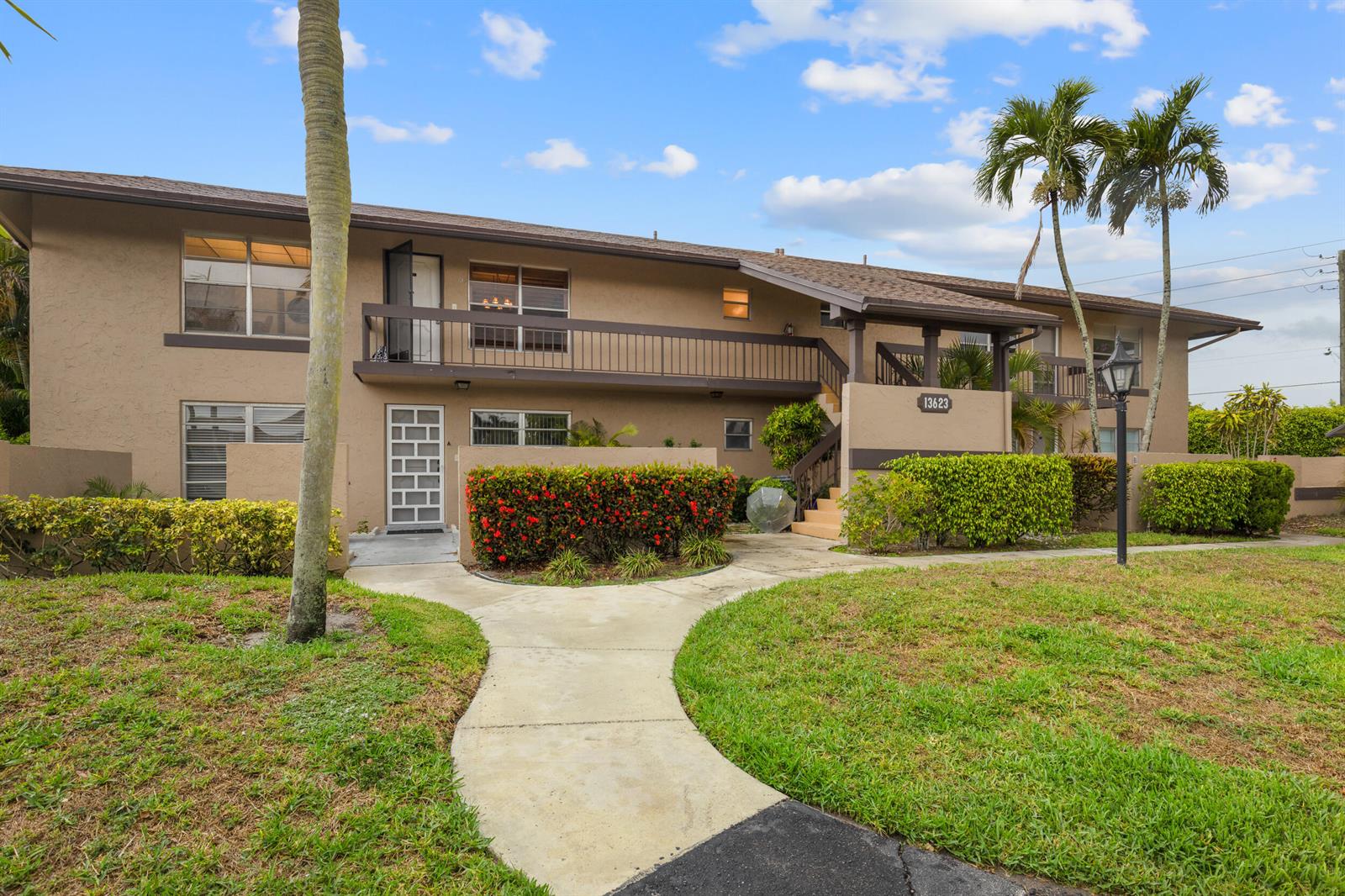 A two-story tan apartment building features a balcony, a walkway, and landscaped bushes — 13623 Via Aurora # C, Delray Beach FL 33484, DELRAY BEACH, FL
