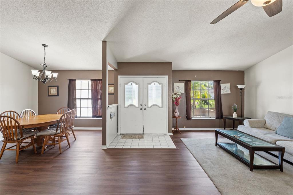 A dining area and living room are separated by a central entryway with double doors — 3077 ARDENWOOD DRIVE, SPRING HILL, FL
