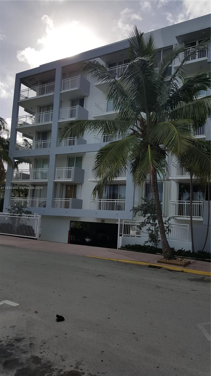 A multi-story apartment building with balconies and a palm tree stands above a parking garage — 7832 Collins Ave # 403, Miami Beach FL 33141, MIAMI BEACH, FL