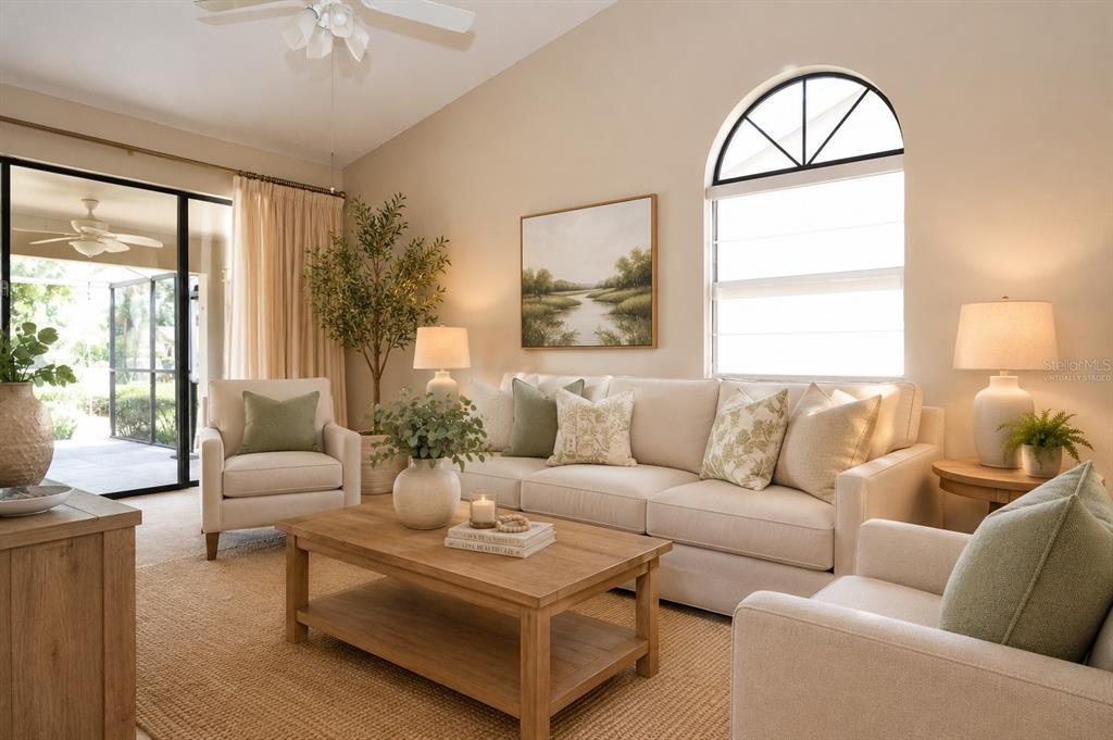 A living room features a beige sofa, two armchairs, a wooden coffee table, and arched windows — 5565 SALEM SQUARE DRIVE N, PALM HARBOR, FL