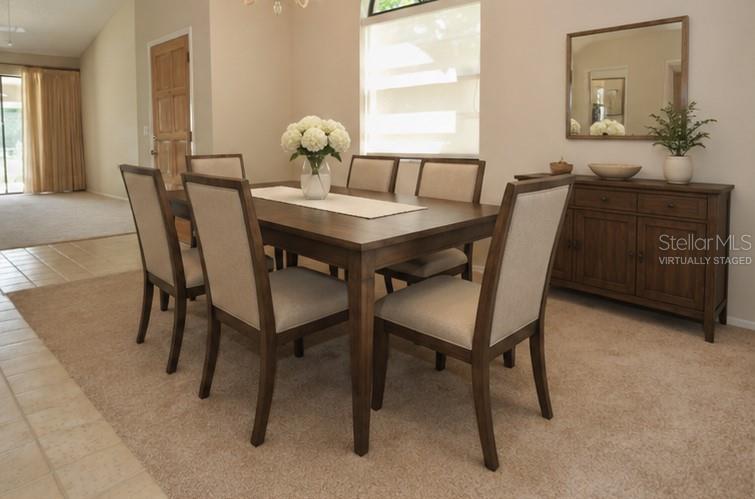 A dining room features a wooden table with six upholstered chairs and a matching sideboard — 5565 SALEM SQUARE DRIVE N, PALM HARBOR, FL