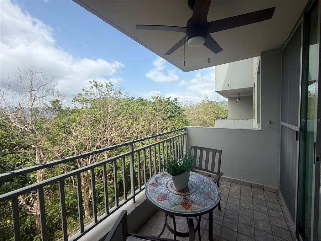A balcony features a tiled floor, a ceiling fan, a mosaic table, and a metal railing — CAMINITO ALTO CARR 189, GURABO, PR
