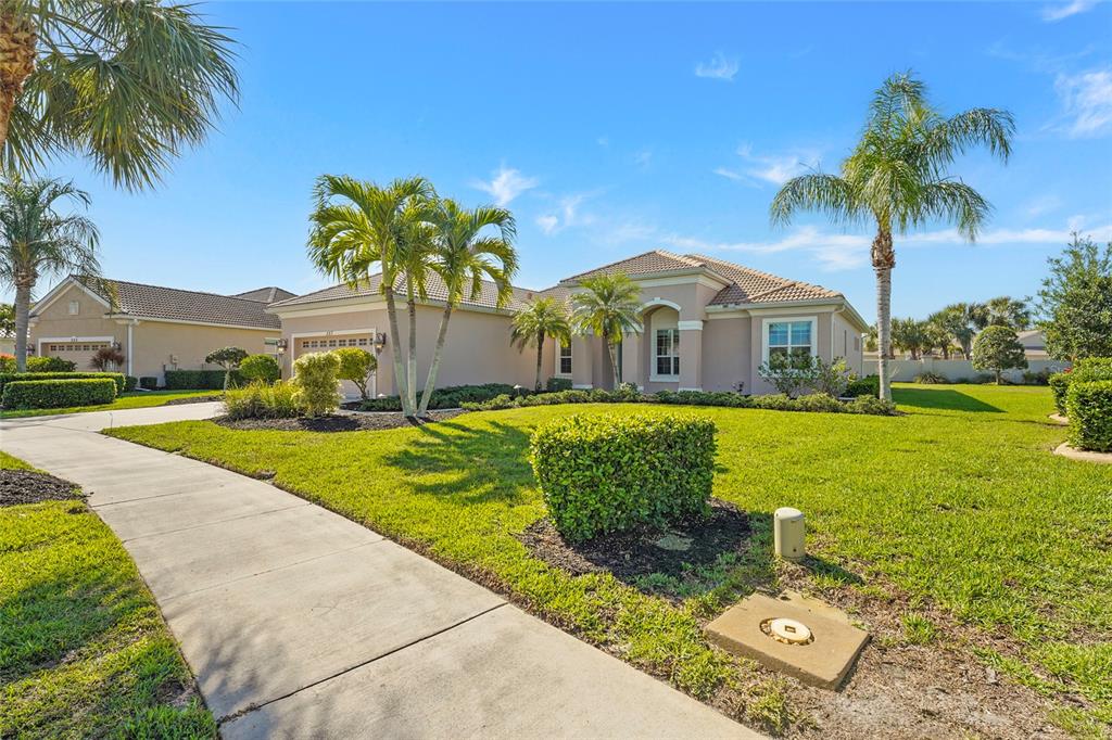 A single-story stucco house with a tile roof, palm trees, and a concrete walkway — 357 MARSH CREEK ROAD, VENICE, FL