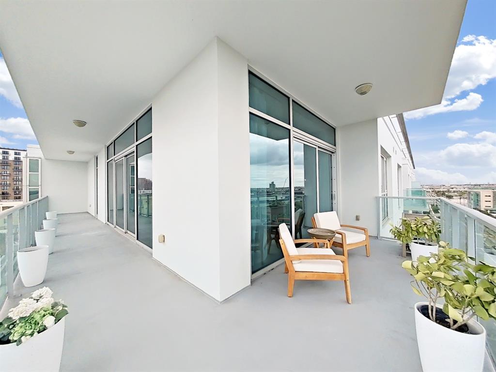A spacious wrap-around balcony features white planters, two wooden chairs, and glass railings — 912 CHANNELSIDE DRIVE UNIT 2805, TAMPA, FL