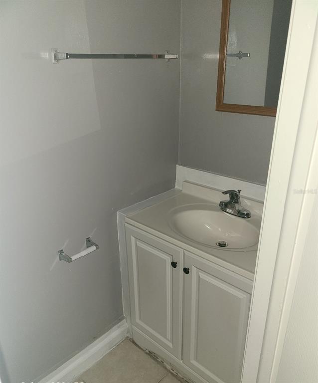 A small bathroom features a gray vanity with a white sink and a towel bar — 4910 SILVER OAKS VILLAGE UNIT B, ORLANDO, FL