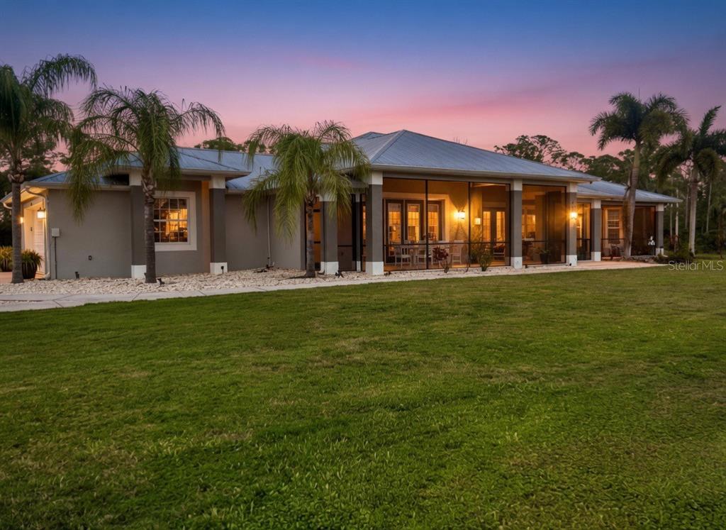 A single-story house with a screened-in porch and palm trees at sunset — 9150 DEER COURT, VENICE, FL